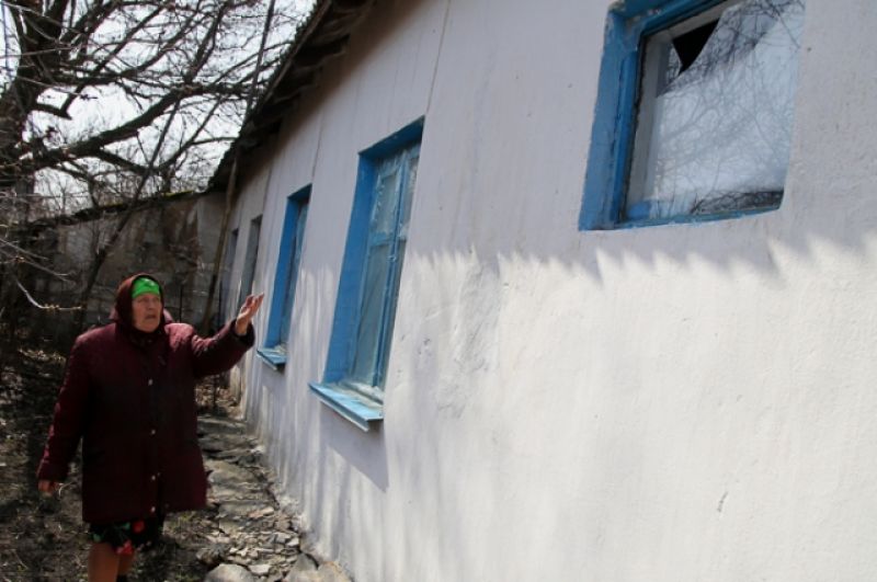 Местная жительница из села Васильевка Донецкой области показывает повреждение в своем доме, пострадавшем в результате обстрела. 