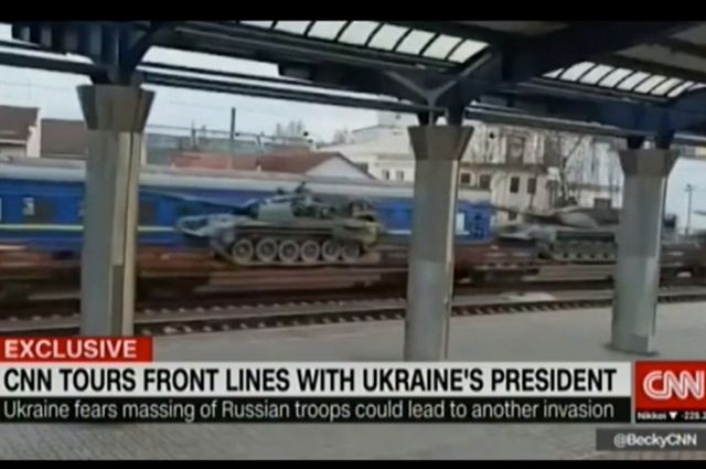 На видео видно, что железнодорожные платформы с танками следуют на фоне пассажирских вагонов в сине-желтой украинской расцветке. Кадр из видео CNN.