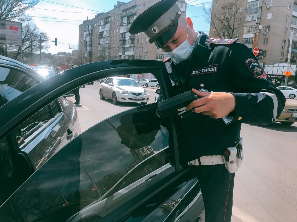 Сотрудник ГИБДД проверяет степень светопропускания тауметром