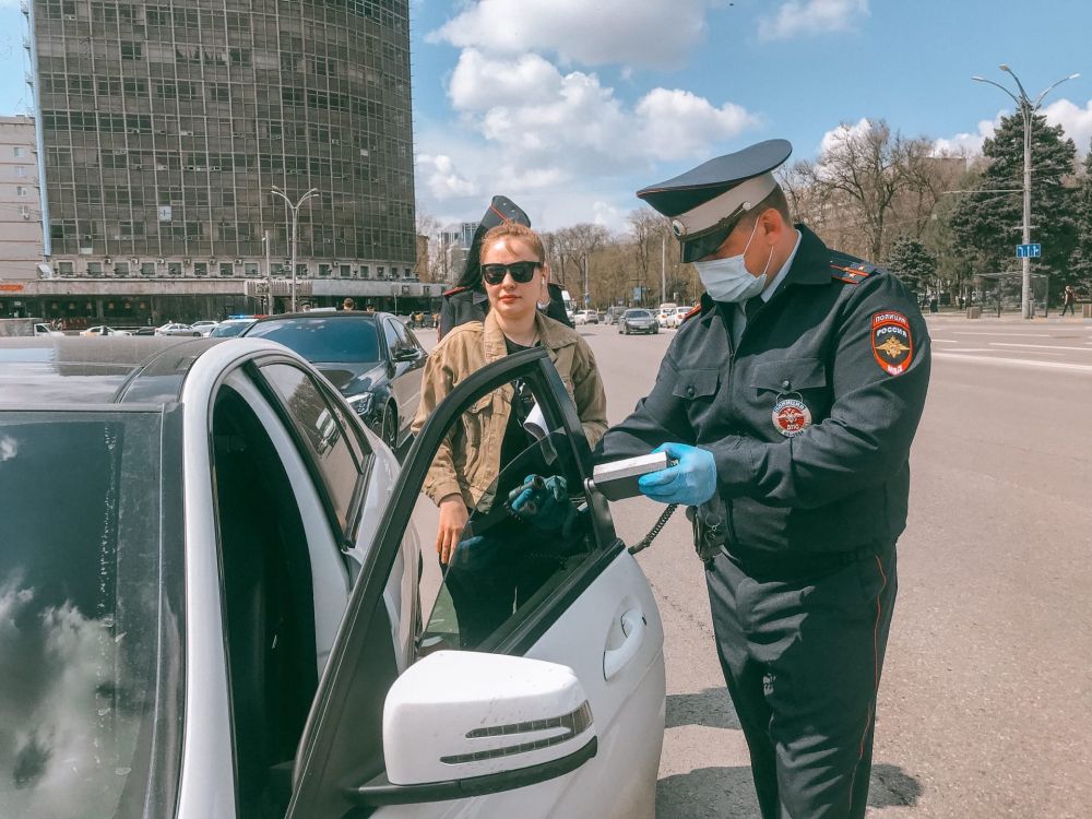 Сотрудник ГИБДД проверяет степень светопропускания тауметром