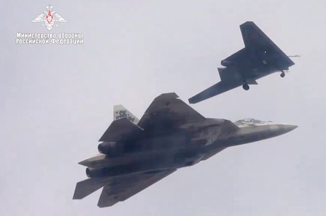 Ударный беспилотник «Охотник» (на втором плане) во время совместного полета с Су-57.