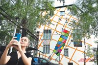 Девушка делает селфи на фоне работы художника Кирилла Кто, выполненной в стиле стрит-арт.