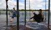 Девушки качаются на качелях на затопленной набережной Енисея в центре Красноярска