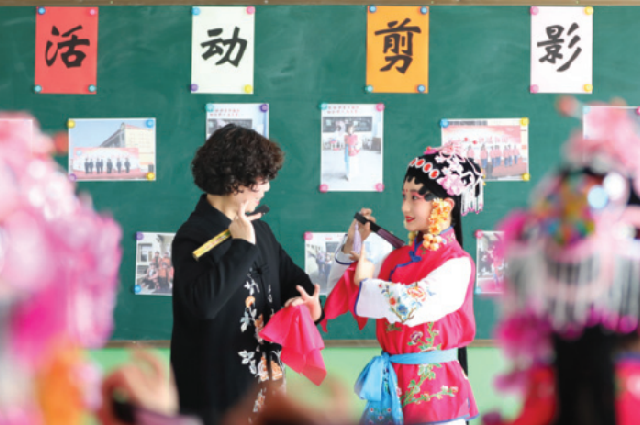 Учитель инструктирует ученика во время занятия по основам Пекинской оперы в начальной школе. Уезд Лунъяо, провинция Хэбэй, апрель. 