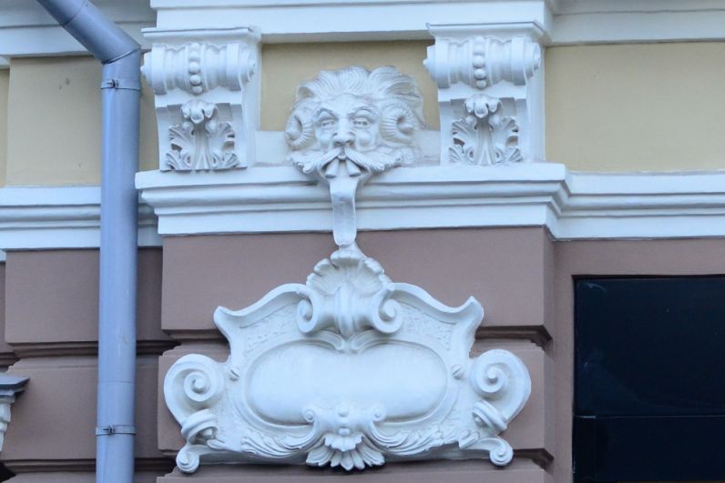 Мифическое существо показывает язык с фасада бывшей гостиницы 