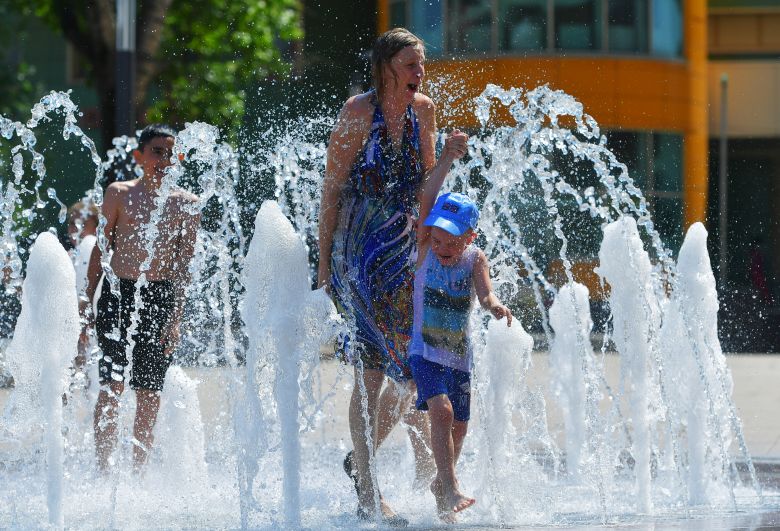 Люди купаются в жаркую погоду в фонтане на одной из улиц в городском округе Троицк в Москве