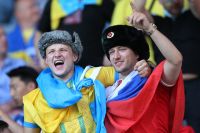 Болельщик на матче Украина — Швеция в майке сборной России, шапке-ушанке с советской кокардой, а также с российским флагом.