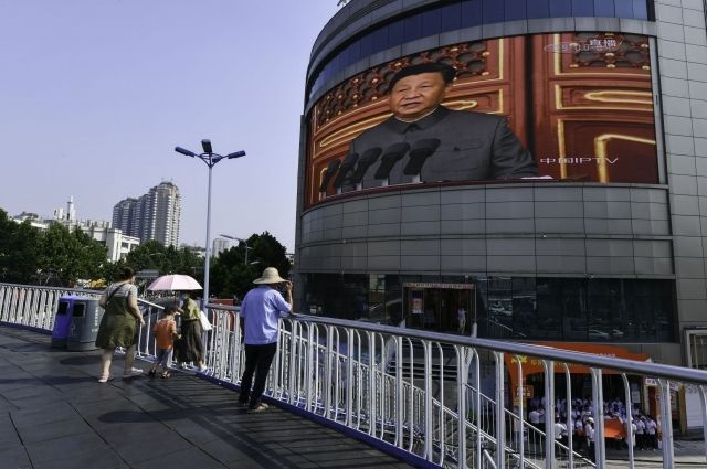 На экране на улице Жэньминь в Фуянге (Китай) видно, как Си Цзиньпин выступает с речью во время празднования столетия со дня основания Коммунистической партии Китая. 