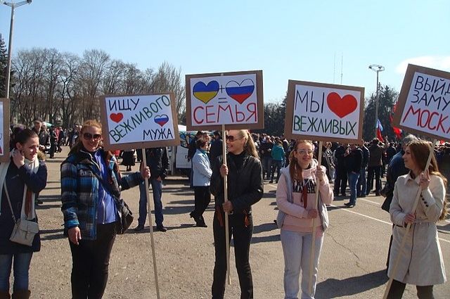Люди в Одессе (Украина) держат плакаты, говорящие о единстве русского и украинского народов, март 2014 г.
