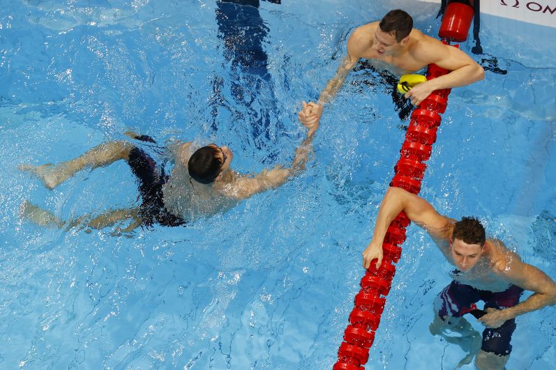 Российский спортсмен Евгений Рылов и австралийский спортсмен Митч Ларкин после финального заплыва на 100 метров на спине среди мужчин на XXXII летних Олимпийских играх