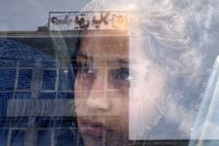 Лицо девочки в отражении от витрины одного из магазинов в Кабуле, Афганистан.