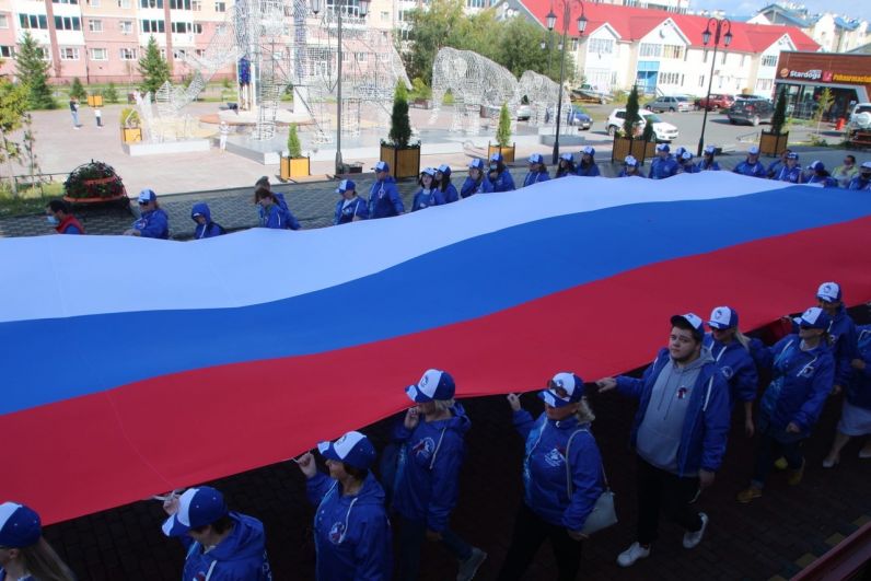 В Салехарде пронесли 15-метровое полотно российского триколора от качельного парка у первой школы до городского сада.