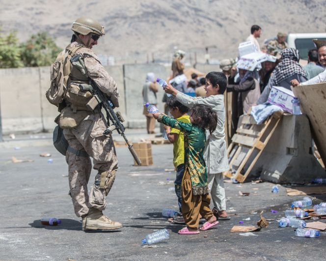 Дети брызгают водой американского военного во время эвакуации людей из Афганистана в международном аэропорту им. Хамида Карзая в Кабуле