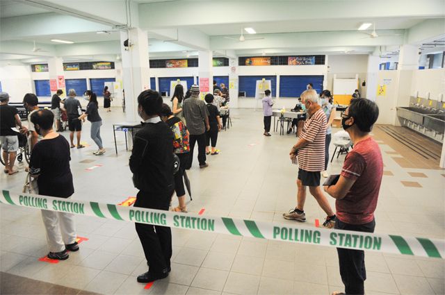 В Сингапуре штраф за неявку на голосование небольшой, но вот за его неоплату лишают избирательного права навсегда. На фото: избиратели стоят в очереди, соблюдая дистанцию, на избирательном участке во время вспышки коронавируса в Сингапуре, 2020 г.