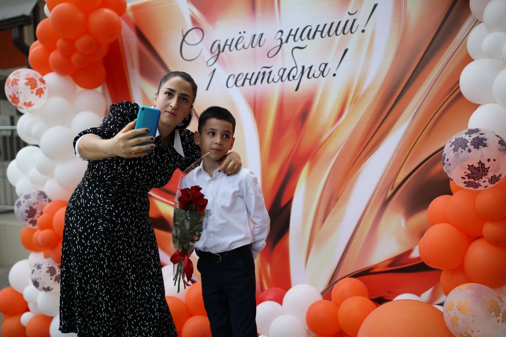 Женщина фотографируется со своим ребёнком во время праздничных мероприятий, посвящённых Дню знаний, в школе №94 в Краснодаре. В этой школе набрали первые классы на все буквы алфавита. Всего в учебное заведение было принято 840 учеников первого класса