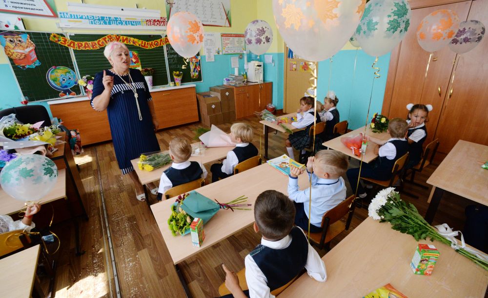 Учитель начальных классов Елена Ивановна Гурман с первоклассниками в классе школы №7 в селе Прохладное Приморского края во время Дня знаний