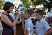 Учительница измеряет температуру школьникам перед началом торжественной линейки, посвящённой Дню знаний возле школе-гимназии №1 в городе Судак