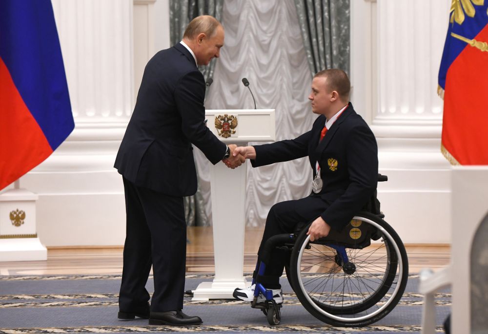 Президент РФ Владимир Путин и чемпион XVI Паралимпийских летних игр по плаванию спорта лиц с поражением опорно-двигательного аппарата в дисциплине 100 м брасс в классе SB5, серебряный призёр в дисциплине 200 м комплексное плавание в классе SМ6 Андрей Граничка (справа) на церемонии вручения государственных наград РФ победителям XVI Паралимпийских летних игр 2020 года в Токио