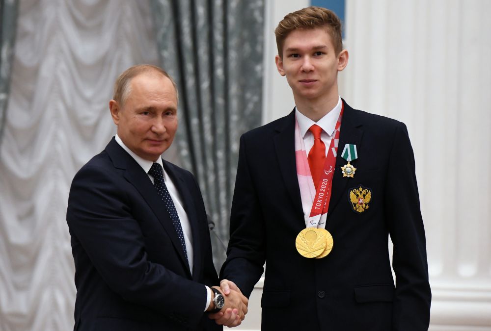 Президент РФ Владимир Путин и двукратный чемпион XVI Паралимпийских летних игр по плаванию спорта лиц с поражением опорно-двигательного аппарата в дисциплине 100 м на спине в классе S9 и в комбинированной мужской эстафете 4x100 м (справа) Богдан Мозговой на церемонии вручения государственных наград РФ победителям XVI Паралимпийских летних игр 2020 года в Токио
