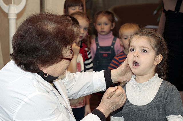 Дети на осмотре у врача перед вакцинацией против вируса полиомиелита.