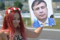 Женщина с пониженной социальной ответственностью из Femen держит портрет Саакашвили у пункта пропуска Краковец на украинско-польской границе.