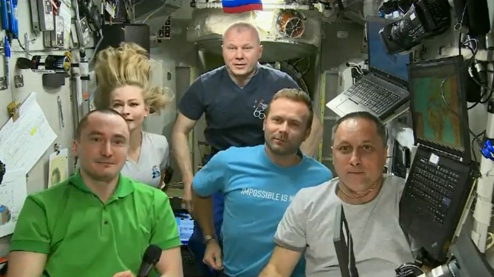 Актриса Юлия Пересильд, режиссёр Клим Шипенко, космонавт Антон Шкаплеров (во втором ряду слева направо), космонавты Пётр Дубров (на первом плане) и Олег Новицкий (на дальнем плане) на Международной космической станции