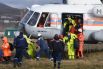 Спасатели МЧС России и эвакуированные члены экипажа контейнеровоза Rise Shine, который сел на мель у берегов Находки, у вертолёта Ми-8