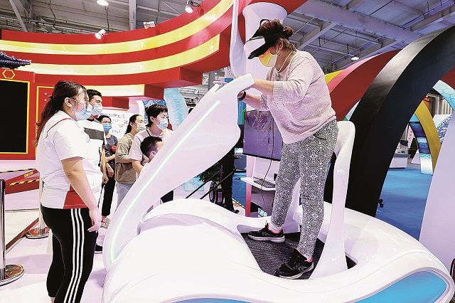 Посетитель (справа) в виртуальной реальности катается на лыжах во время Китайской международной ярмарки по торговле услугами, проходившей в Пекине 4 сентября 2021 г.