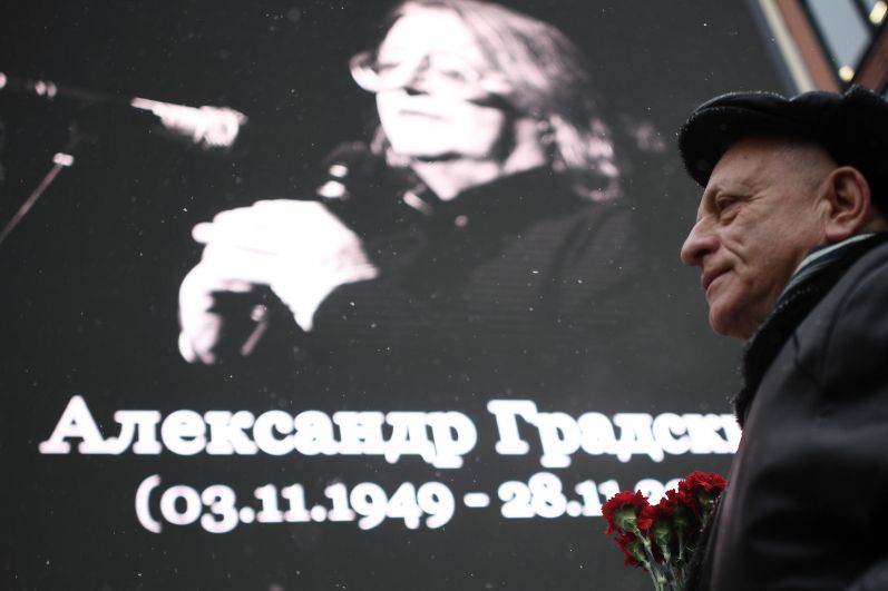 Мужчина с цветами у театра «Градский холл», где проходит церемония прощания с народным артистом России Александром Градским