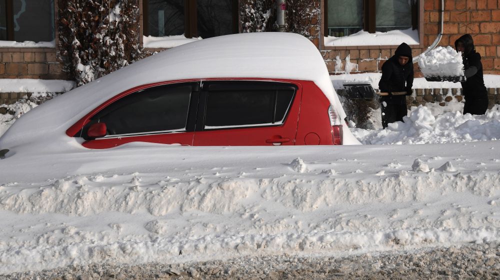 Заснеженный автомобиль на улице Суханова во Владивостоке после сильного снегопада