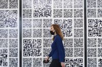 Посетительница у стены с QR-кодами в технопарке имени Попова в Иннополисе.