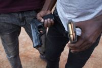 Негр бандит показывает свое оружие. Члены общины иммигрантов, добывающие золото на приисках в Йоханнесбурге. Гаутенг, Южная Африка, 2021 г.