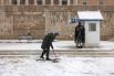 Сотрудник президентской гвардии Греции чистит снег перед могилой Неизвестного солдата в Афинах