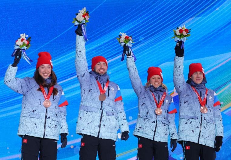 Российские спортсмены, члены сборной России (команда ОКР) Ульяна Нигматуллина, Александр Логинов, Кристина Резцова и Эдуард Латыпов (слева направо), завоевавшие бронзовые медали в смешанной эстафете по биатлону на XXIV зимних Олимпийских играх 2022, на церемонии награждения