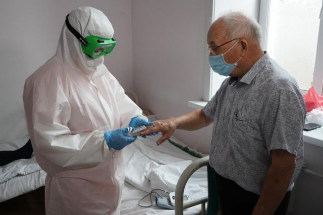 Главврач проводит осмотр пациента с коронавирусной инфекцией