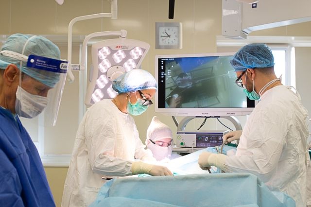 Валерия Саевец (слева) вместе с коллегами вырезает у пациентки пятикилограммовую опухоль.