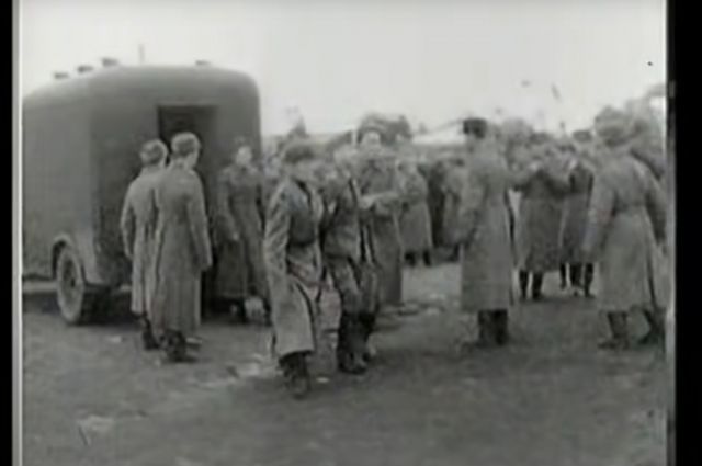 Военных национал-социалистических преступников ведут на казнь. Кадр из документального фильма «Суд идёт» 1943 года о Харьковском судебном процессе.