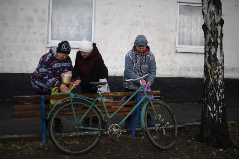 Женщины складывают гуманитарную помощь, полученную от общественной организации «Пища жизни. Донбасс», в селе Крымское