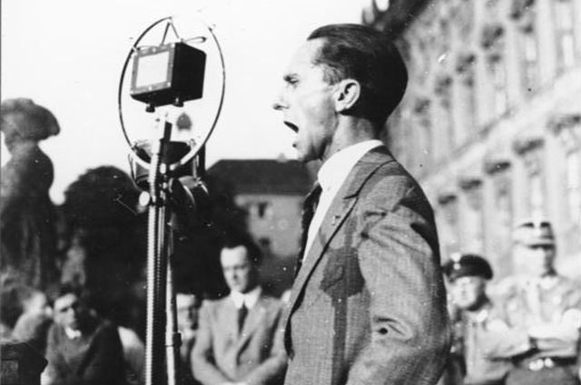 Геббельс выступает в берлинском Люстгартене, июль 1932 год. Поза акимбо должна была внушить слушателям властный статус оратора.