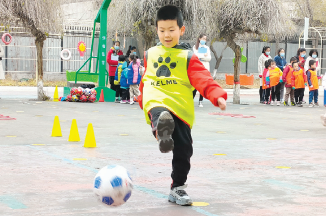 Ребенок играет в футбол в детском саду № 7 города Урумчи в Синьцзян-Уйгурском автономном районе.