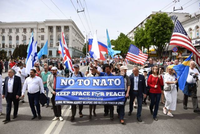 Представители Швеции, США, Великобритании, Израиля и Непала несут транспарант с надписью «Нет НАТО» во время первомайского шествия в Симферополе. 