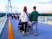 Семейная пара с колясками прогуливается по Мосту Влюбленных.