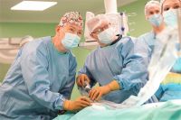 Новые технологии позволяют хирургу, глядя на экран, видеть пациента «изнутри». Юрий Козлов (слева) в операционной.