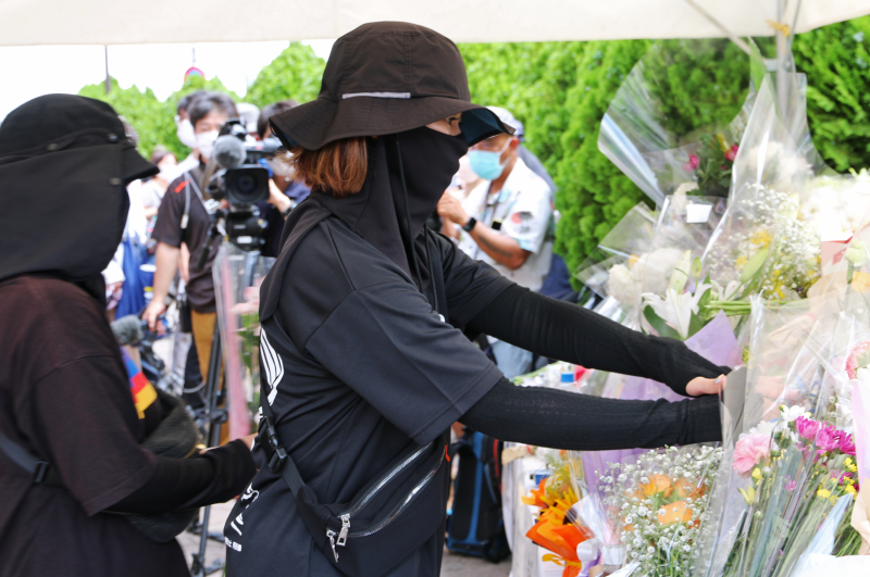 Люди несут цветы к месту, где стреляли в Синдзо Абэ. 