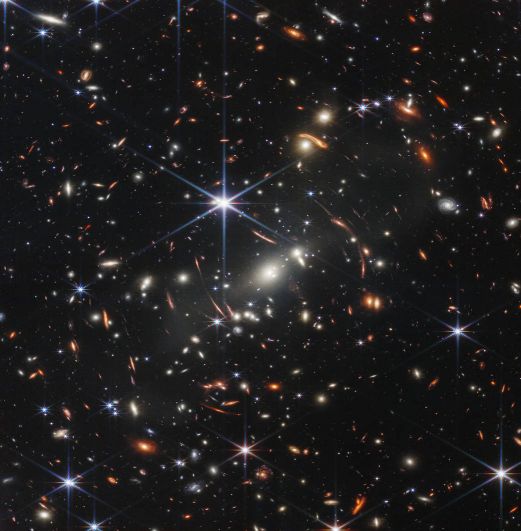 На этом изображении показано скопление галактик SMACS 0723 в том виде, в каком оно появилось 4,6 миллиарда лет назад, с большим количеством галактик впереди и позади скопления