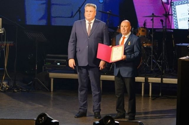 Вице-губернатор Олег Николаев поздравляет прессовщика горячих труб Александра Шиловского.