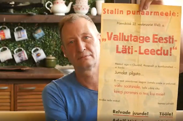 Дмитрий Хмелёв демонстрирует листовку эстонских фашистов, призывающих воевать на стороне фашисткой Германии.