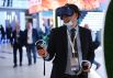 Участник Восточного экономического форума во Владивостоке демонстрирует очки виртуальной реальности
