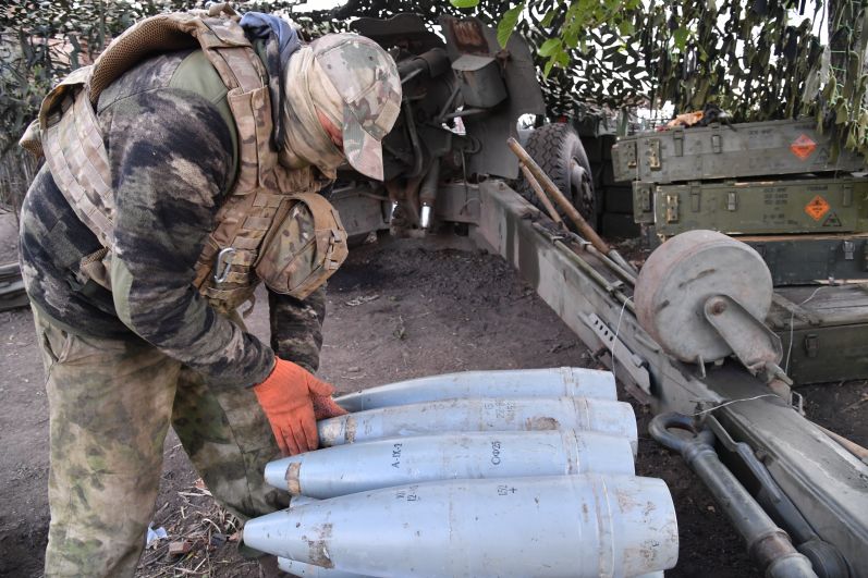Боец артиллерийского расчета ЧВК «Вагнер» у снарядов к гаубице Д20. Бойцы обстреливают позиции ВСУ рядом с Бахмутом в Донецкой области.