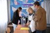 На избирательном участке в Мелитополе сотрудникам выдают переносную урну и бюллетени для проведения голосования на дому.